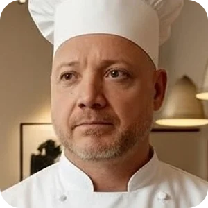 Damián Negron wearing a white chef’s hat and jacket